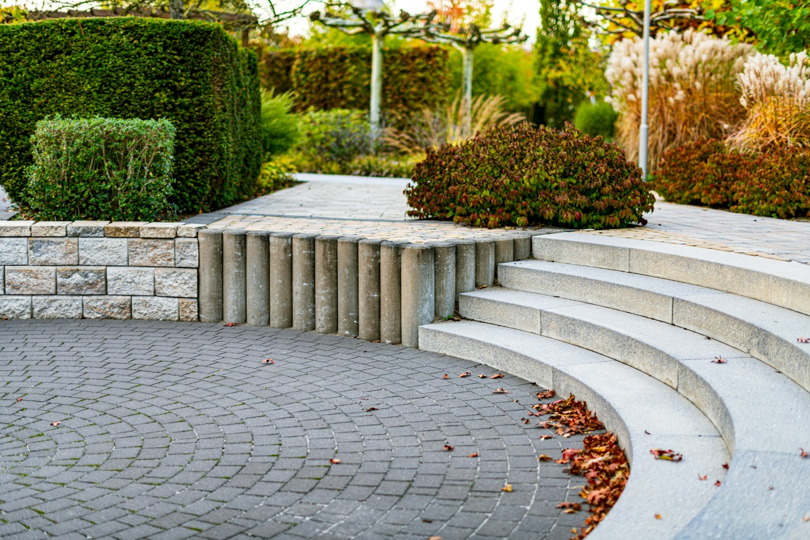 Geschwungene Natursteinstufen in herbstlich bepflanztem Garten